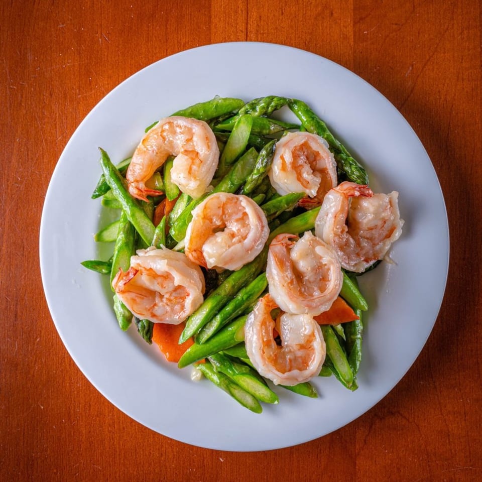 Modern Fusion's shrimp and asparagus stir-fry with carrots on a white plate.