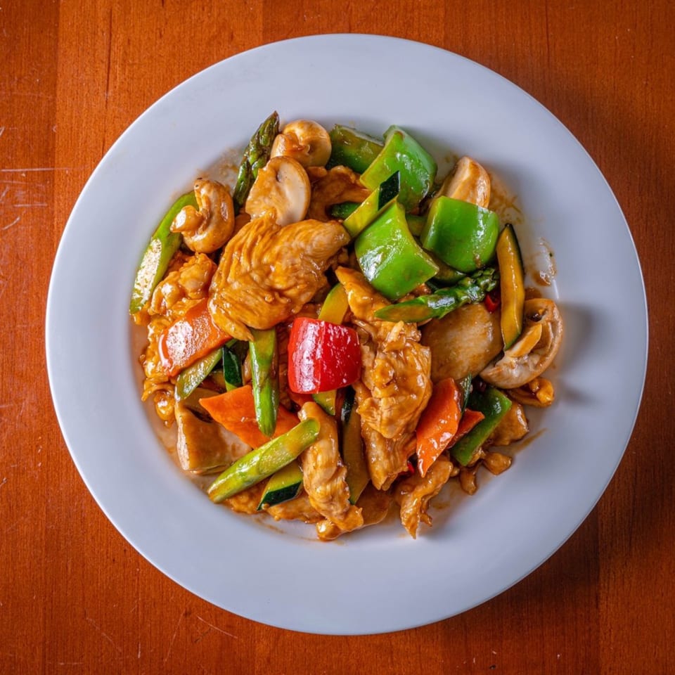 Modern Fusion's Asian-fusion stir-fry with chicken, bell peppers, mushrooms, and asparagus on a white plate.